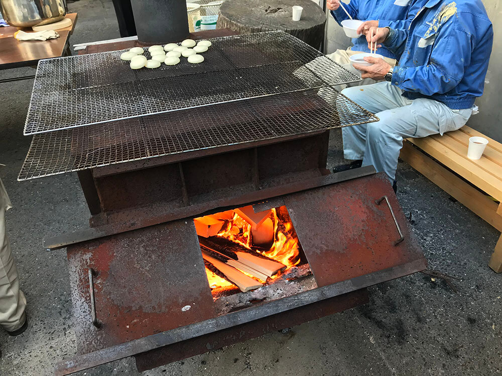 ヒノキの端材をくべたストーブで餅焼き