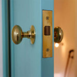 カラフルでかわいい水色の木製室内ドアと、おしゃれな真鍮ノブ