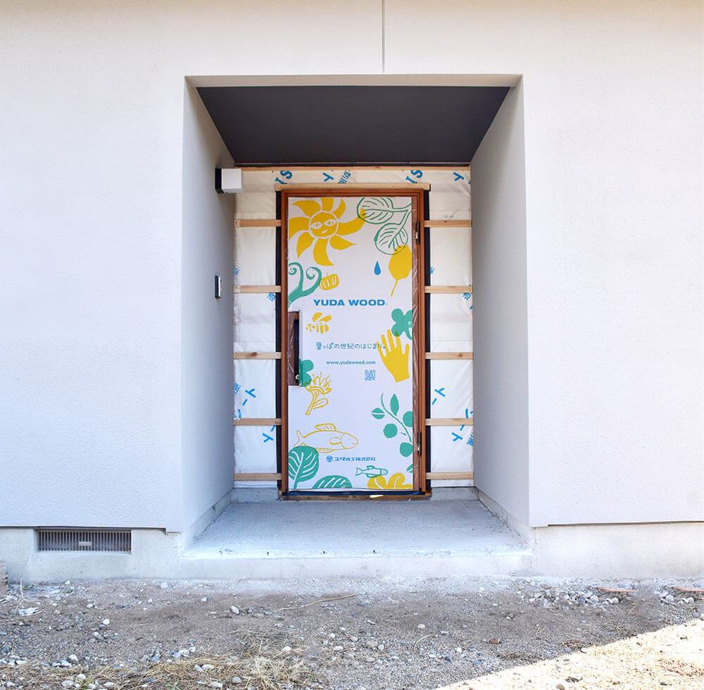 建築現場で玄関に設置された、新パッケージの木製玄関ドア